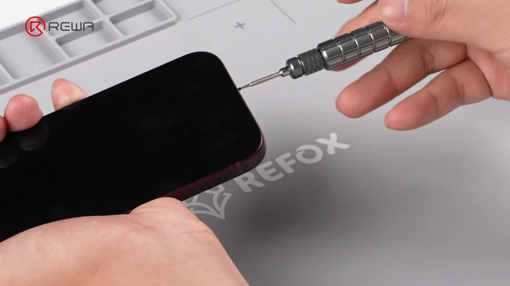 iphone 18 pro teardown: what changed inside and how does it affect repairability Removing the bottom screw of an iPhone using a precision Pentalobe screwdriver
