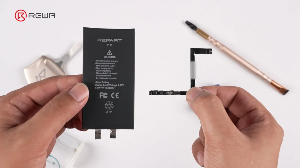 how iphone aftermarket battery bms boards are made Hands holding a black iPhone 14 battery cell on the left and a small BMS board with flex cable on the right